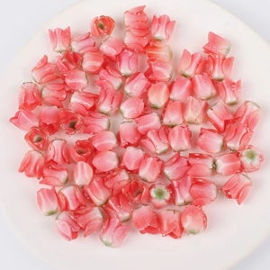 Macro shot of pink tulip-shaped acrylic beads with water droplets on a white plate