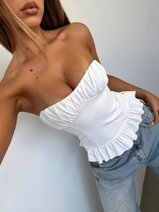 White Y2K tube top with pleated chest and ruffle hem on model wearing light blue jeans