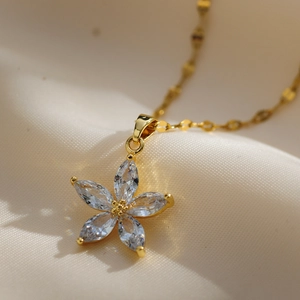 Close-up of gold flower necklace with white marquise cut zircon petals on silk