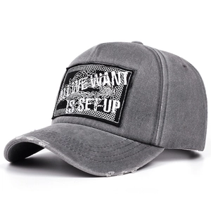 Close-up of vintage grey washed cotton baseball cap with letter embroidery and distressed brim