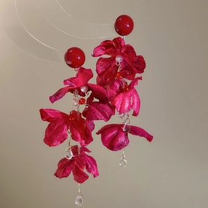 Detailansicht der roten Seidenblumen-Ohrringe mit goldenen Ketten und Kristalltropfen