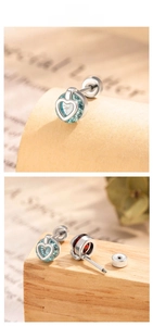 Detail of heart-shaped blue zircon stud earrings with silver finish and screw back closure