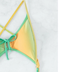 Sexy yellow-green gradient bikini top with adjustable neck ties on marble background