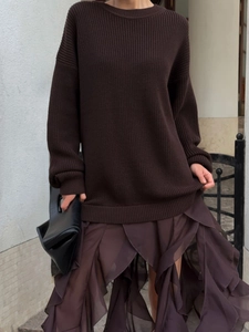 Oversized dark brown knit sweater with irregular tulle skirt and black leather clutch bag