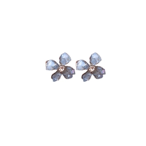 Eleganti orecchini a fiore con petali in cristallo blu e perni in argento su sfondo bianco