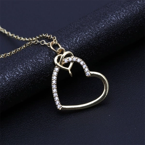 Macro detail of a golden heart pendant featuring sparkling zircon pave inlays