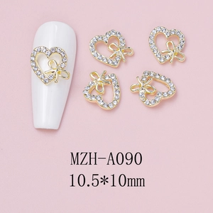 Detailed view of hollow heart nail art charm with gold metal bow and crystals