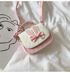 Detail of pink bow and rabbit ears on quilted faux leather crossbody bag for girls