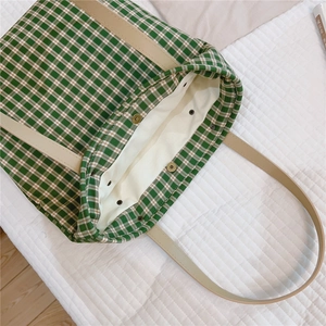 Vue détaillée du sac cabas en toile à carreaux verts avec boucle en métal et anses