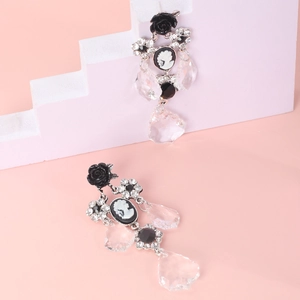 Close-up of vintage cameo earrings with black resin roses and clear crystal tassels