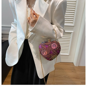 Detail of heart-shaped evening bag featuring purple sequins and floral embroidery