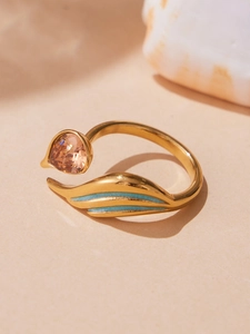 Detailed close-up of water drop champagne zircon and blue enamel leaf on golden ring