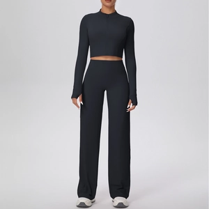 Détail de la veste courte zippée noire et du pantalon de yoga taille haute évasé