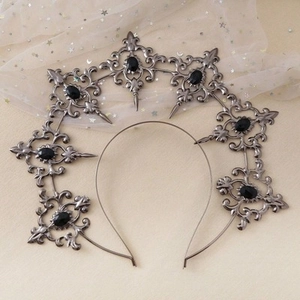 Detailed macro view of Gothic silver tiara with black gems and intricate patterns
