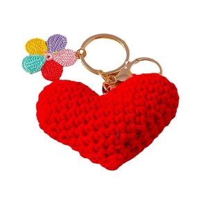 Handmade knitted red heart and floral keychain with golden metal ring on white background