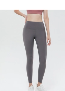Detail showing high-waisted compression waistband on dark grey peach-lift yoga pants