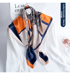 Detailed view of 90cm silk scarf with orange and navy geometric floral patterns