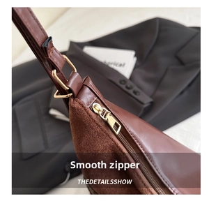 Detail of smooth leather and suede stitching on tote bag with golden metal zipper