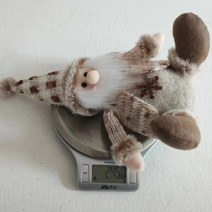 Detail shot of a handmade Christmas gnome on a digital scale showing a weight of 245 grams