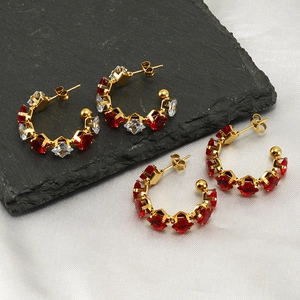 Luxury gold C-shape hoop earrings with red and white zircon on black rock and white silk