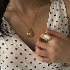 Ensemble collier pendentif nautile et bague agate blanche en or 18 carats sur mannequin