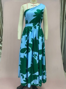 Detail of light blue one-shoulder maxi dress with green leaf print and high waist line