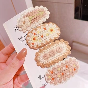 Detailed macro of four handmade crochet floral hair clips with soft knitted textures