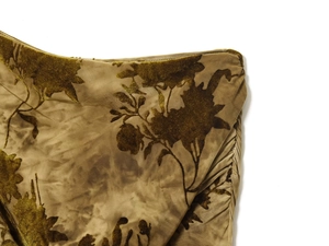 Detail of olive green velvet burnout fabric with floral patterns and pleated sewing texture