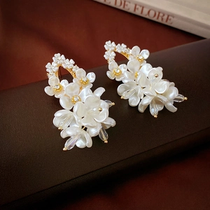 Elegant white acrylic flower stud earrings with sparkling crystals and golden base