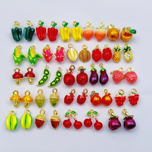 Flat lay of colorful fruit and vegetable enamel charms for DIY jewelry making