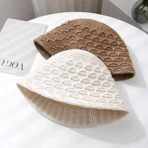 Detail of hollow knit bucket hat showing intricate scale-like relief texture and weave