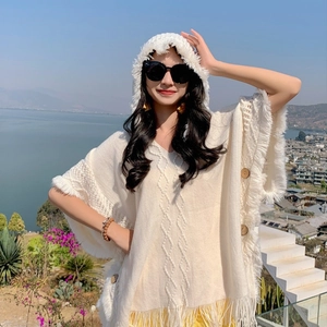 White knitted hooded poncho featuring long fringes and vintage wooden buttons for vacation
