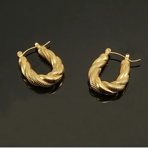 Macro shot of 18K gold plated U-shaped twisted hoop earrings with fine woven texture