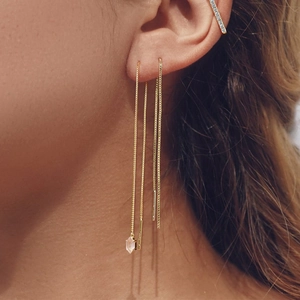 Detail of gold tassel ear wire with hexagonal crystal and pave diamond ear cuff on ear