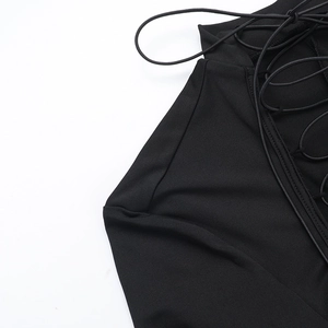 Détail de la robe noire à manches longues avec laçage élégant et découpes sur le côté