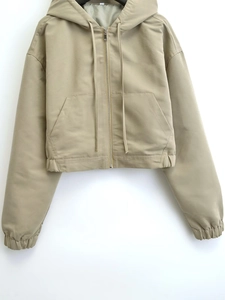 Detail of khaki cropped hoodie jacket featuring metal zipper and adjustable drawstring