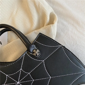 Schwarze PU-Leder-Handtasche mit weißer Spinnennetz-Naht und stilvollem Metallkreuz-Nieten-Detail.