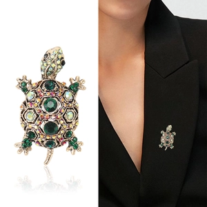 Vintage crystal turtle brooch with green rhinestones shown on model and white background