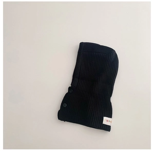 Detail of black knit balaclava for kids with woven FIERO label and button texture