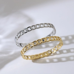 Modern gold and silver Cuban chain hollow bracelets displayed on white fabric background