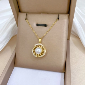 Macro detail of gold necklace with pearl sunflower pendant in a luxury jewelry gift box