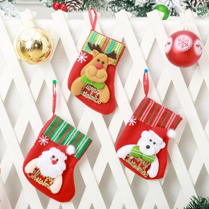 Three Christmas stockings with 3D Santa, reindeer, and bear hanging on a festive fence