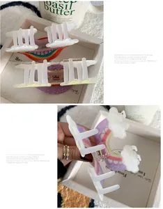 Detailed macro view of cute acrylic rainbow cloud hair claw clips with spring mechanism