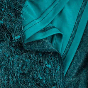 Detailed macro shot of dark green textured fabric with soft feather-like fringe finish