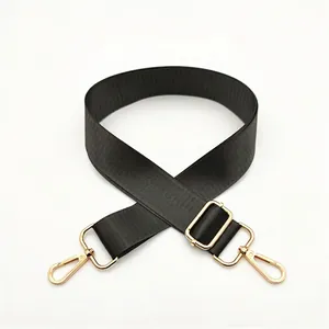Adjustable black nylon shoulder strap with gold metal hardware for handbags