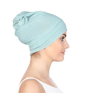 Side view of pleated mint green chemo turban hat showing knit texture and fit for women