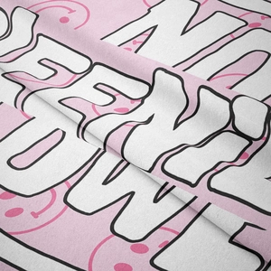 Detail of pink bohemian tapestry fabric with graffiti letters and smiley face pattern