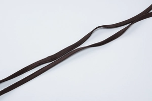 Detail of thin dark brown straps and textured fabric of the backless summer jumpsuit