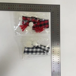 Plaid Christmas bottle covers with red tassels and white pom poms in packaging