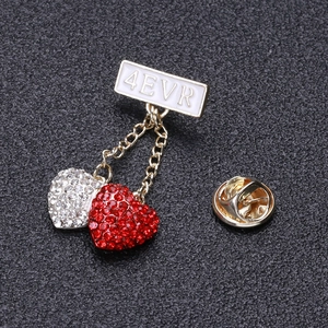 Macro detail of 4EVR bar brooch with hanging red and white rhinestone hearts
